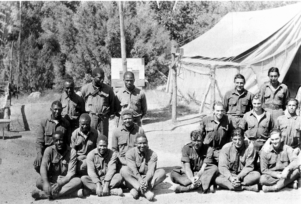 Enrollees of CCC Company 864, including the company's African American contingent, seated outside a tent camp in Arizona, 1933